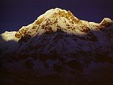 205 Annapurna South At Sunrise From Annapurna Sanctuary Base Camp Annapurna South was one of the first mountains to receive the rising sun at Annapurna Sanctuary Base Camp. �Modi Peak [Annapurna South] from the Sanctuary looked impregnable. Steep, furrowed ice flutings led up to summit cliffs capped by bulging ice walls that threatened to engulf any midget men struggling on the lower slopes. The wall between the two mountains was ploughed with ice flutings that swept down gracefully between angular rock buttresses; its turreted crest was dominated by the Fang, well-named, for it was shaped like the tooth of a wolf and framed from forbidding black rock. There seemed no lines of weakness in the wall and certainly no line free from threat of avalanche� (Chris Bonington, Annapurna South Face).